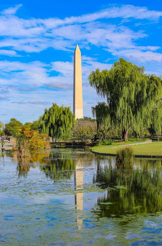 Lago do Constitution Gardens reflete a imagem do Obelisco ao fundo