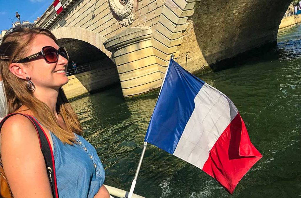 Mulher admira a Pont Neuf desde um barco que navega pelo Rio Sena, em Paris