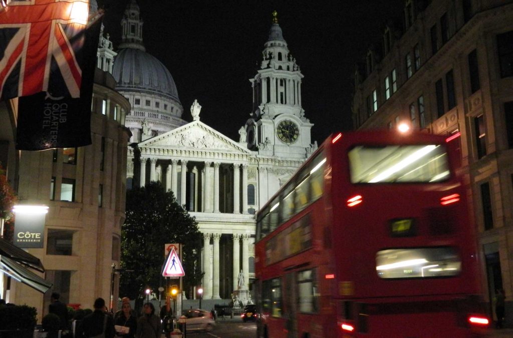Ônibus vermelho passa em frente da Catedral de Saint Paul à noite, em Londres