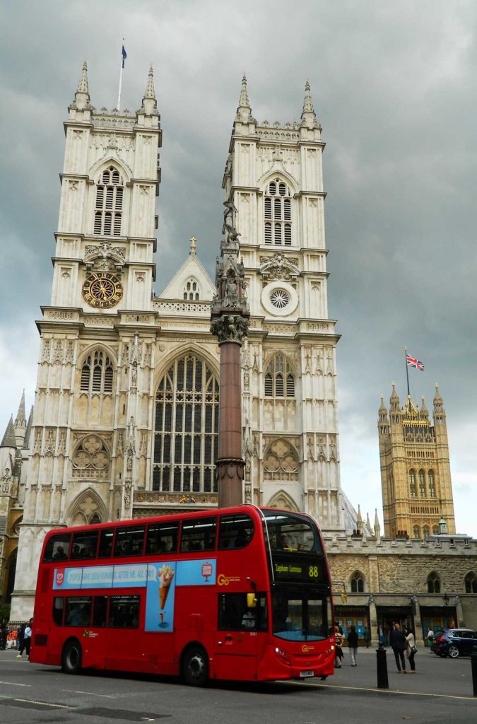 Ônibus vermelho passa em frente à Abadia de Westminster, em Londres