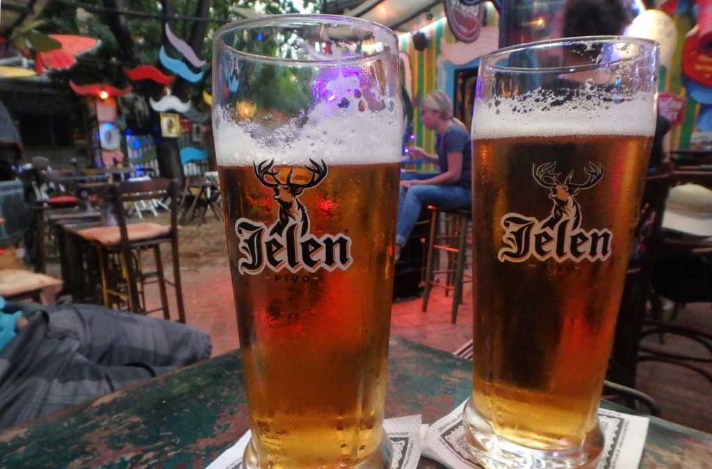 Copos da cerveja sérvia Jelen servidas em mesa de pub