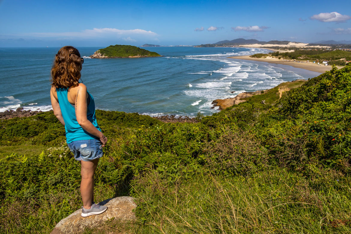 Mulher admira a vista da trilha entre as praias de Ibiraquera e do Rosa