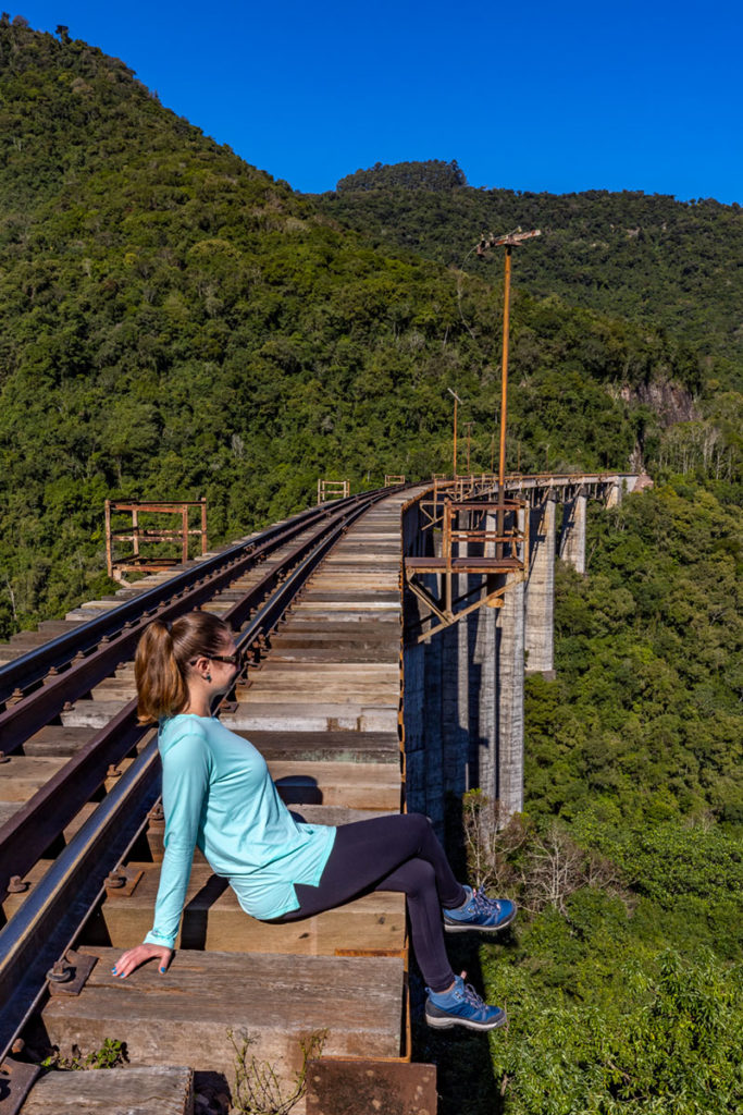 Mulher posa para foto sentada nos trilhos vazados do Viaduto 11