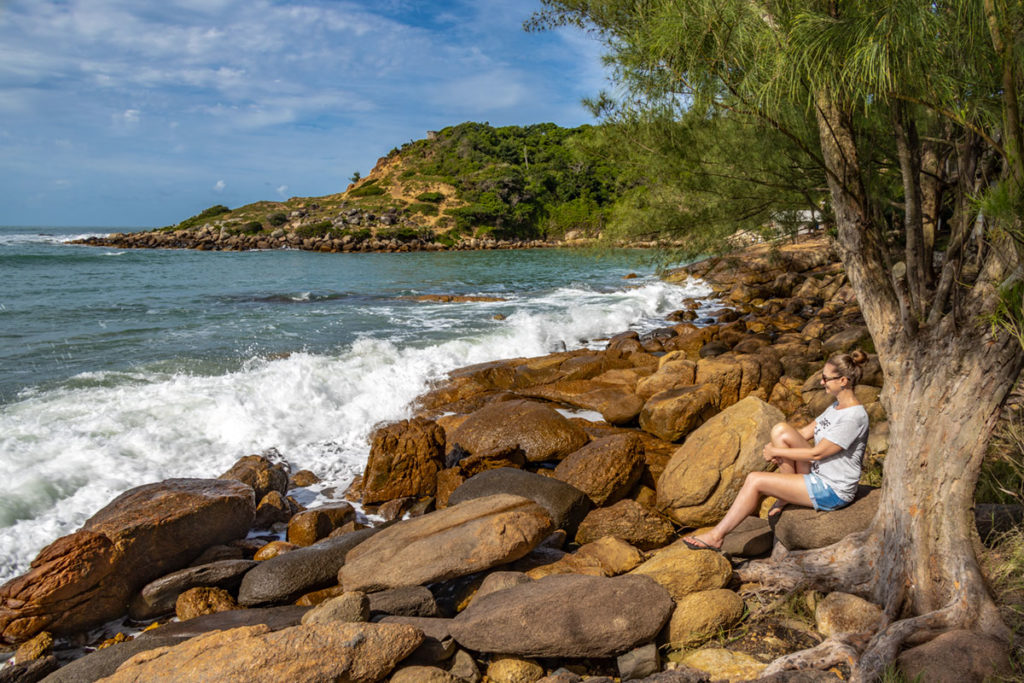 Mulher posa para foto na trilha para a Praia do Amor